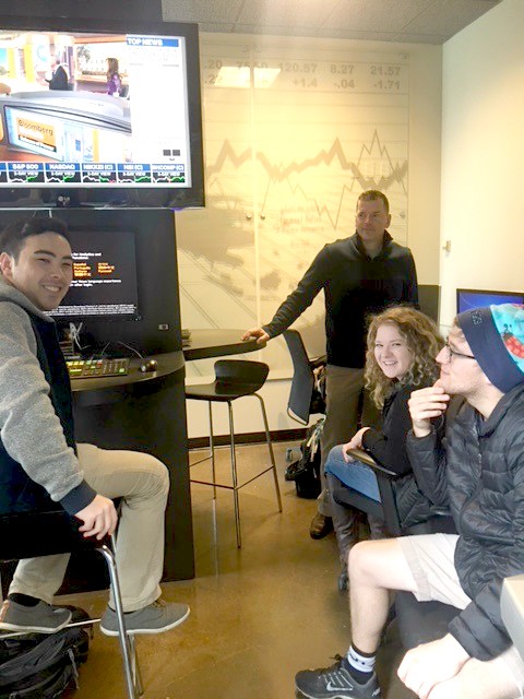 Three students and professor at Bloomberg Terminal
